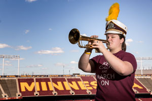 Kelly Miller plays the trumpet in her marching band uniform in TCF Bank Stadium