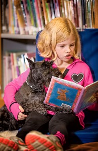 A student reads to Fury, the literacy dog.