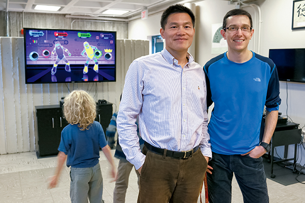 Zan Gao, center, and Zachary Pope, right, in their Williamson Hall lab as kids move to the game “Just Dance” on the Microsoft Xbox360.