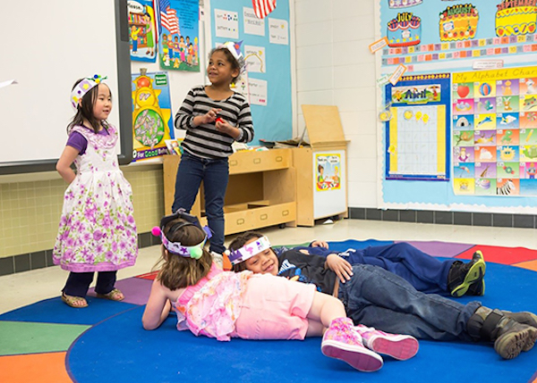Photo: Children don costumes and act out a scene together in a classroom.