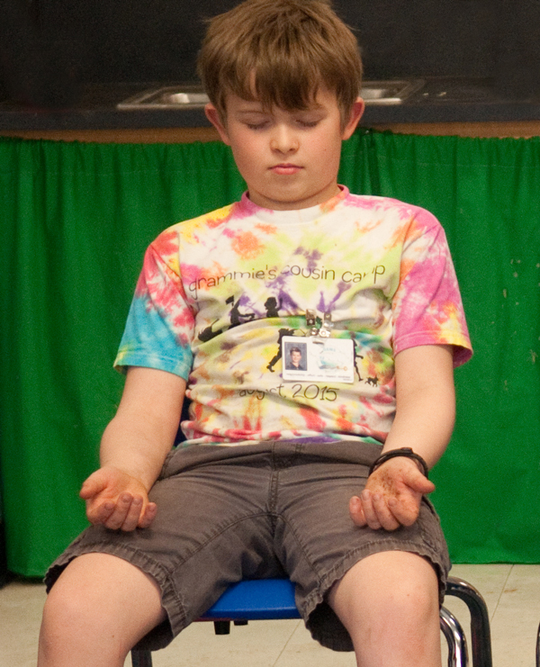 Photo: A boy seated in a chair practices mindful breathing independently.