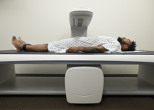 Photo: The DXA scanner arm moves slowly from head to toe to gather data on bone, muscle, and fat.