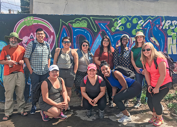 The 2017 class poses next to street art in Mexico.