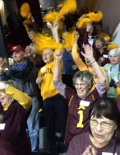 Study participants from Minnetonka Senior Services cheer at a Gopher volleyball game.