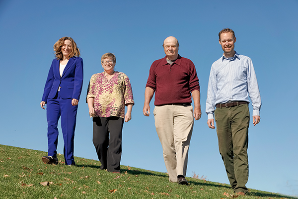 Photo of four prevention science faculty/staff walking on a hillside