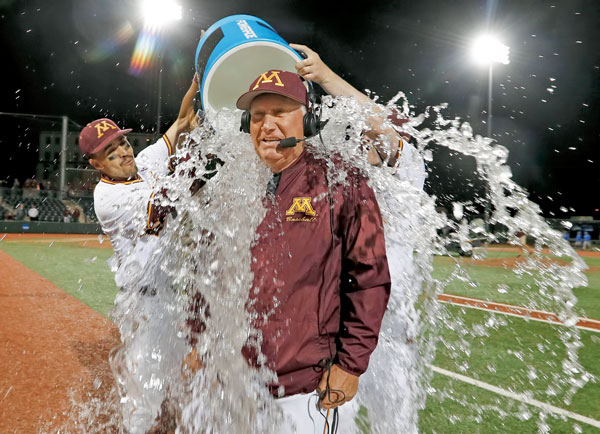 Coach Anderson getting doused with buckets of water by players on the field