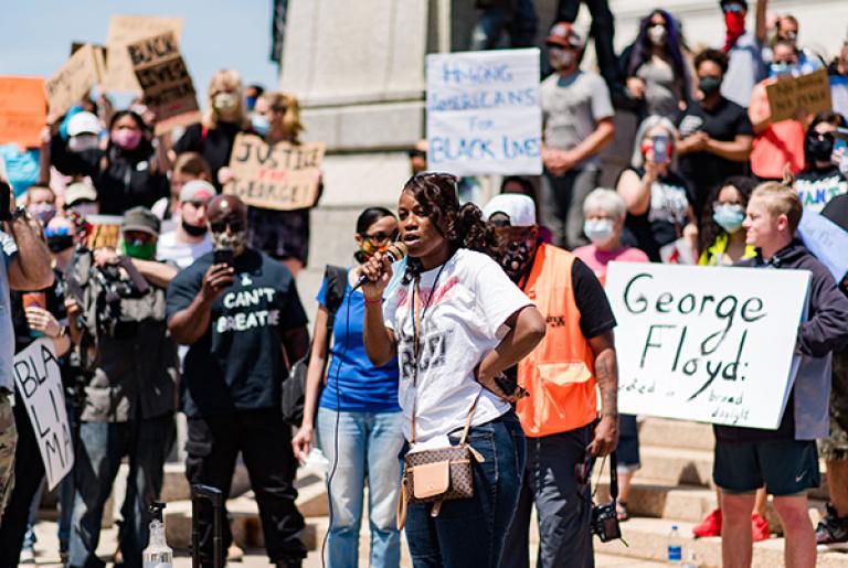 Person speaking to a crowd at a protest