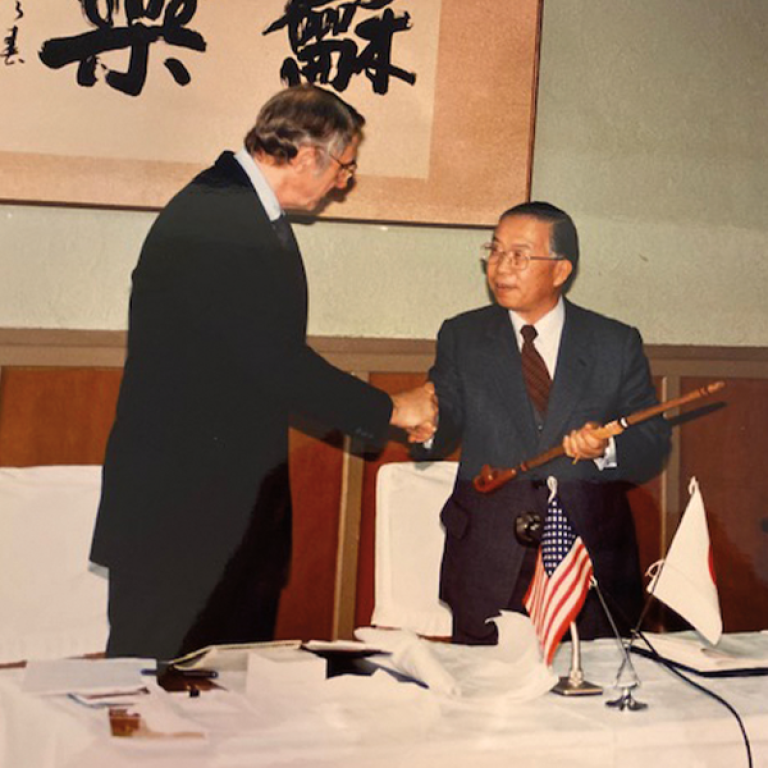 Gardner presents a peace pipe he purchased in Pipestone, Minnesota, to the Japanese at the inaugural Japan-U.S. Teacher Education Consortium in 1990.