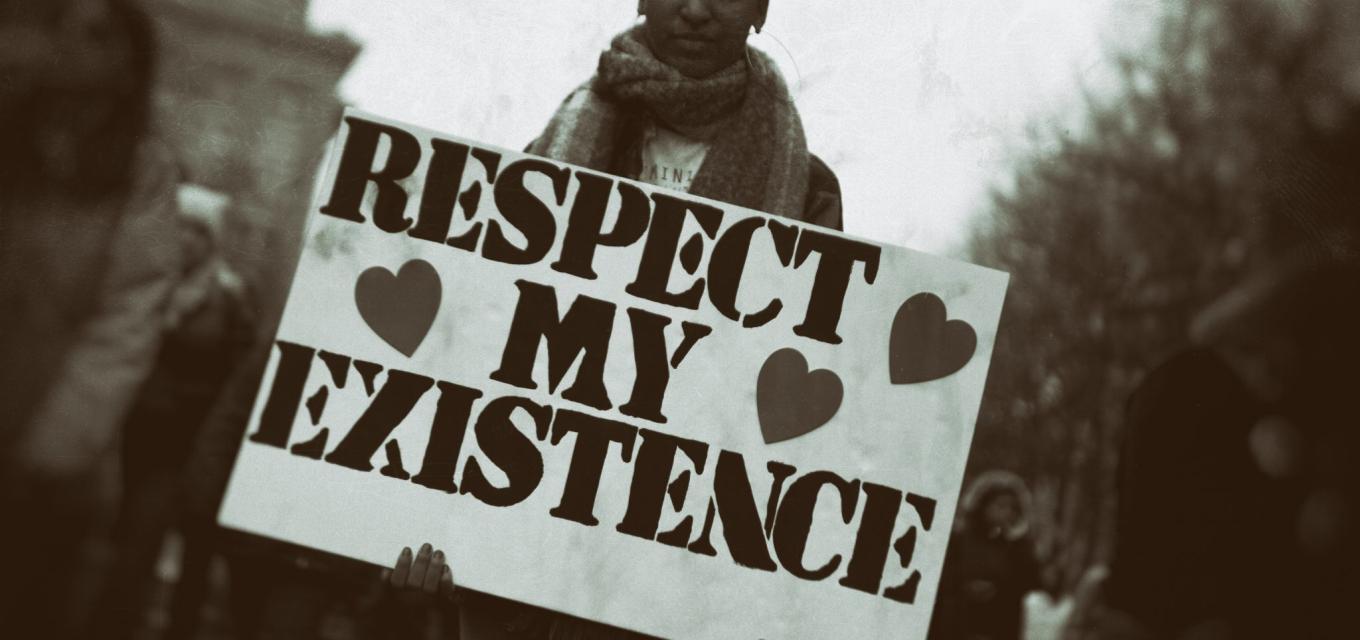 A person holding a respect my existence sign