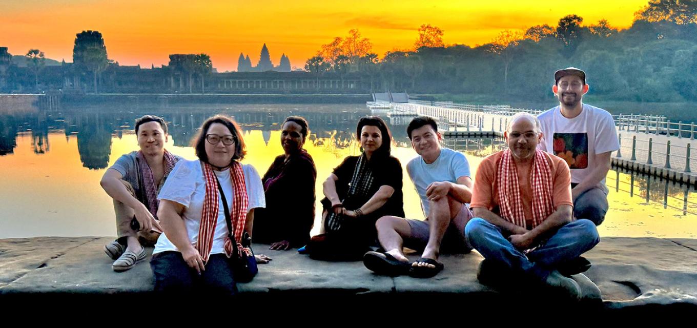Group sitting by the river at sunset