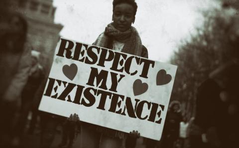 A person holding a respect my existence sign