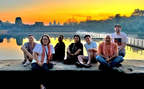 Group sitting by the river at sunset