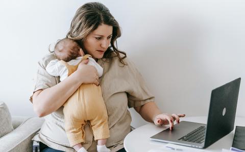 Mother with infant on laptop for telehealth