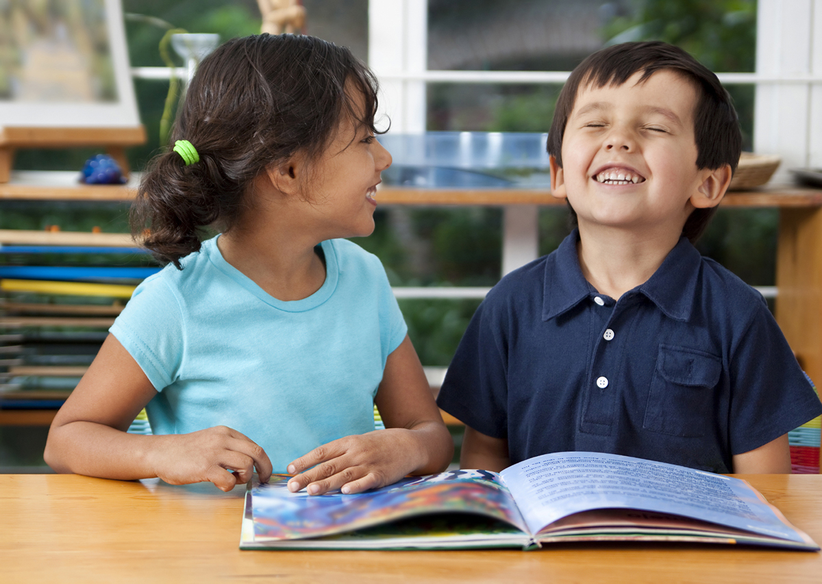 Two young students reading and smiling