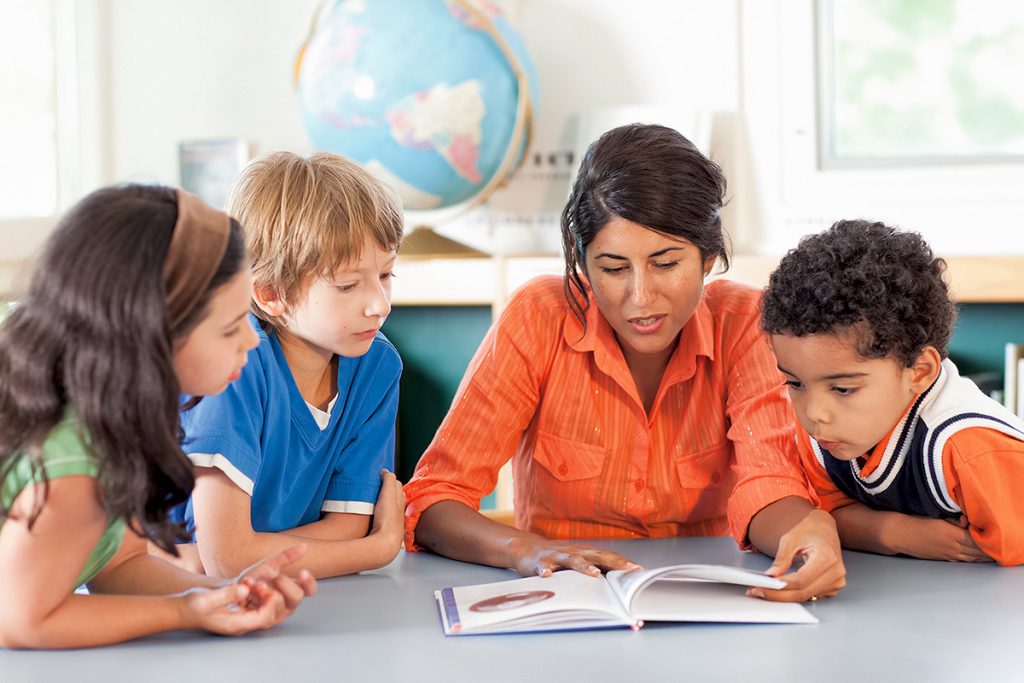 Teacher reading to three students