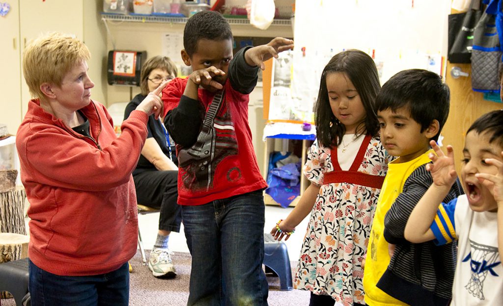 Photo: Students practice their roles with support from an Early Bridges classroom teacher.