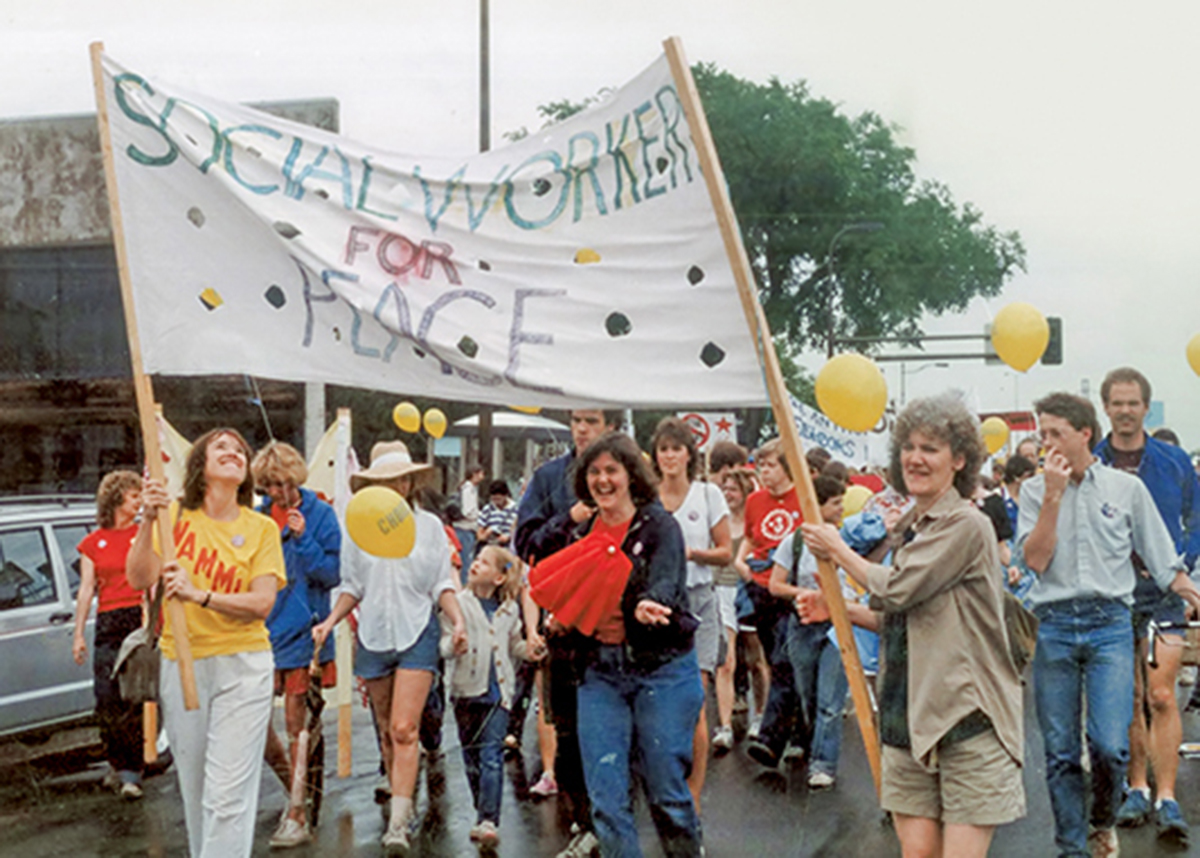 A group of social workers marches with a banner reading "Social workers for peace" in the early 1980s.