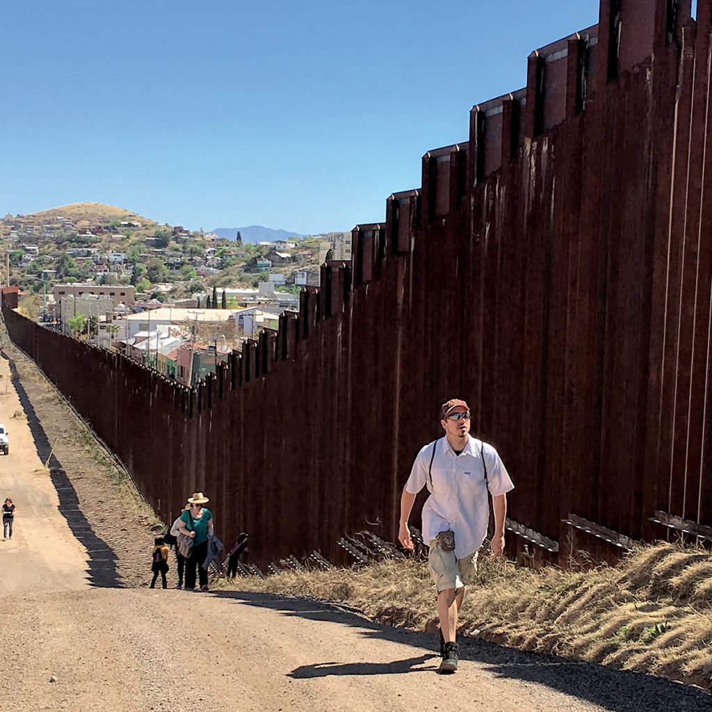 Students walk along the wall between Nogales, Arizona, and Nogales, Mexico.