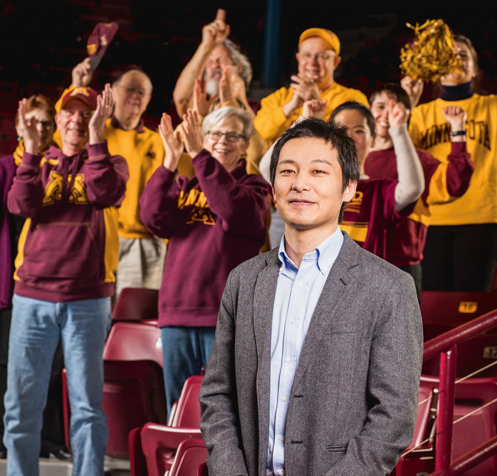 Professor Yuhei Inoue stands with fans wearing Gopher gear