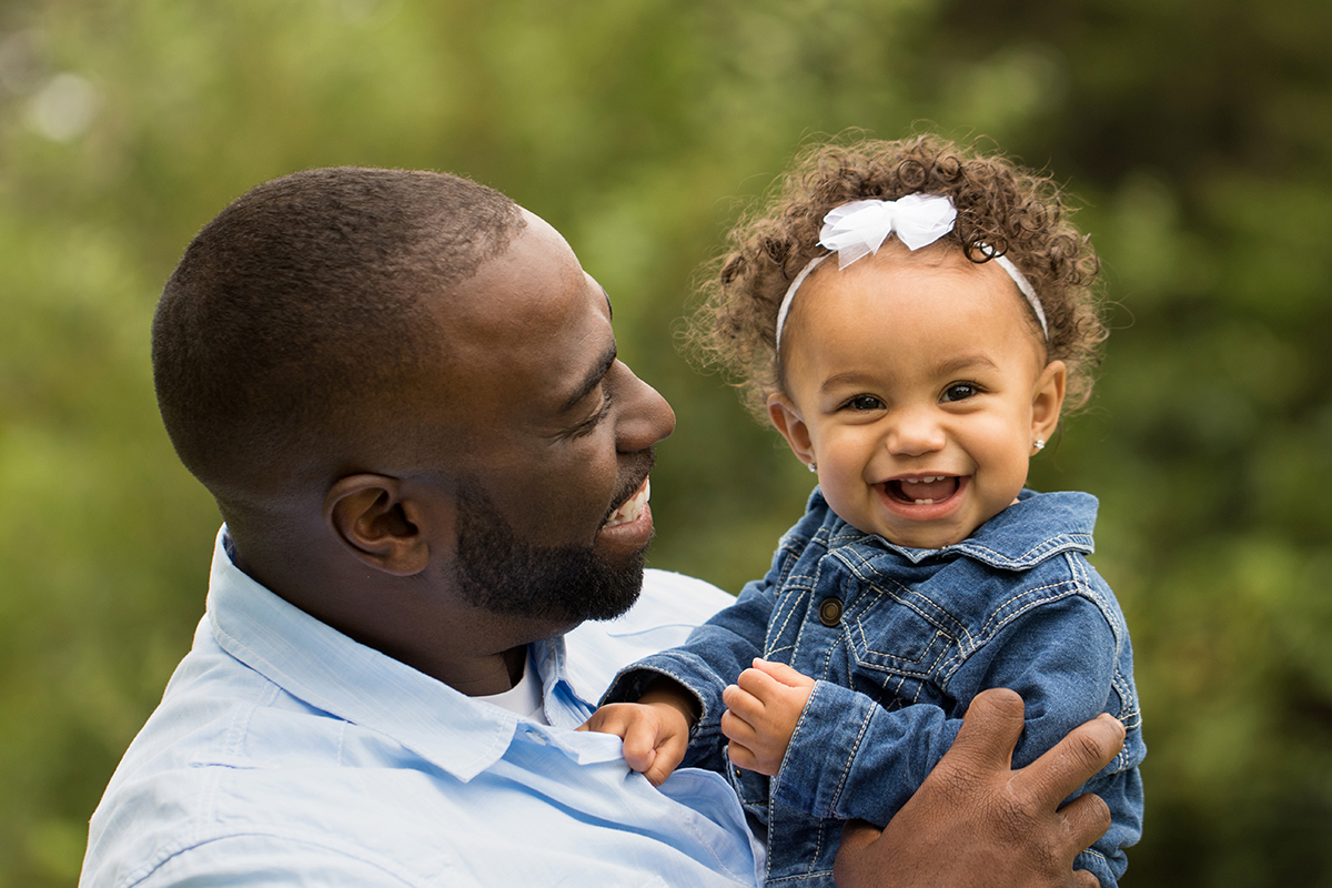 Adorable little girl laughing. Mixed family. Portrait of a African American father and bi-racial daughter.
