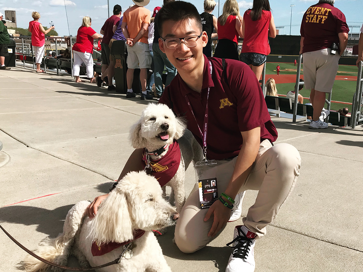 Yuran Wang at baseball field with dogs