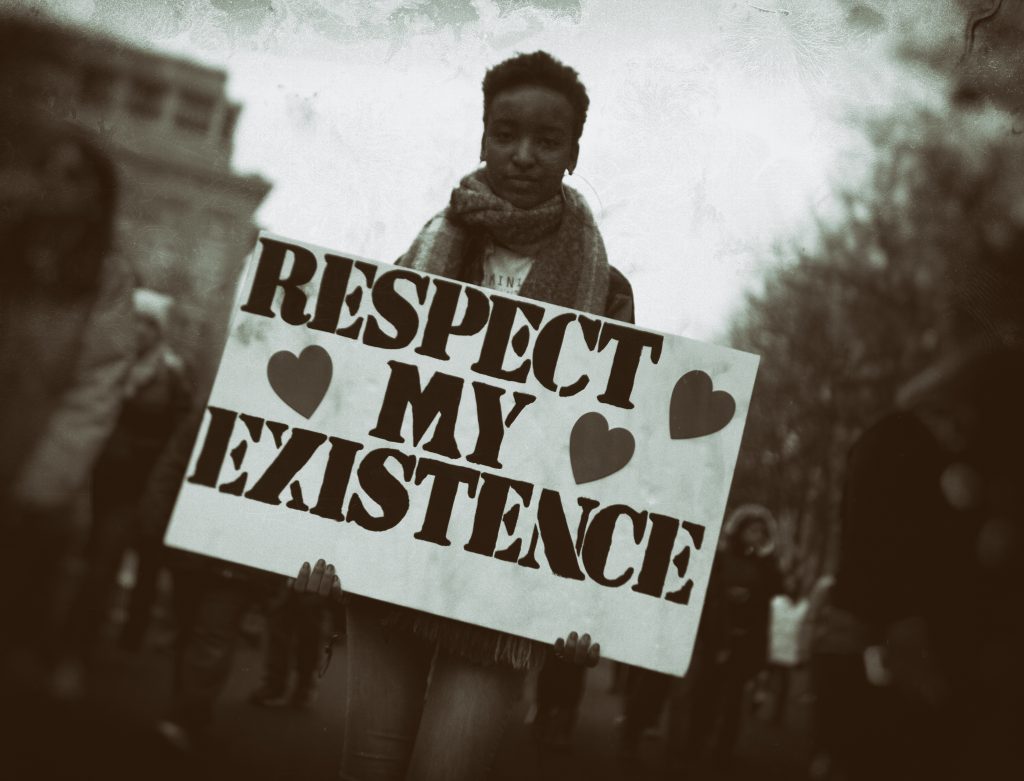 A person holding a respect my existence sign